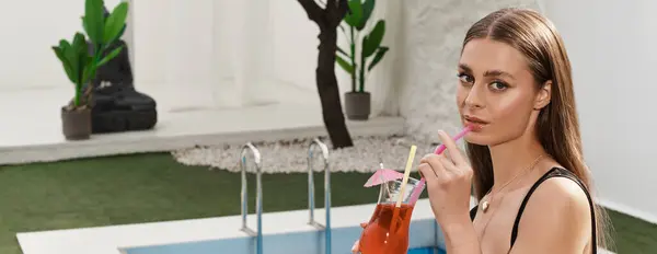 A young beautiful woman relaxes with a colorful drink by the pool in a sunny summer atmosphere. — Stock Photo