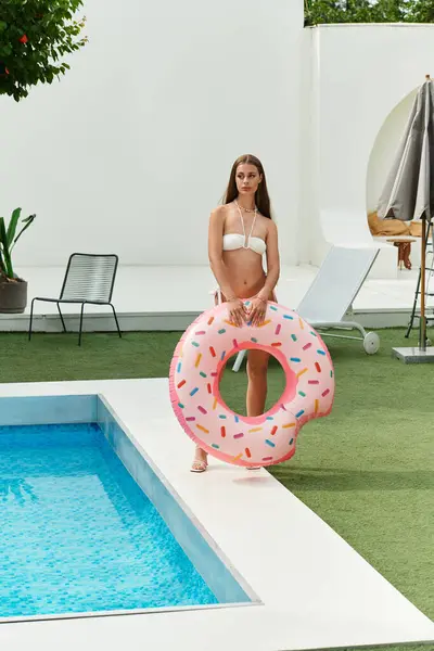 Young woman enjoys a sunny day outdoors near a refreshing pool, ready for summer fun. — Stock Photo