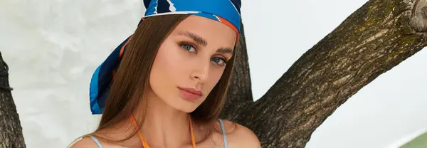 A young beautiful woman relaxes outdoors, embracing the summer warmth with a stylish headscarf. — Stock Photo