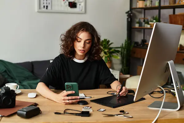 Young woman with curly hair focuses on photo editing using a graphic tablet while seated at home. — Stock Photo