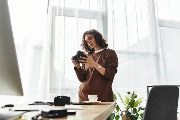 Curly-haired woman reviews her camera settings as she embraces remote work from a sunny home office. — Stock Photo