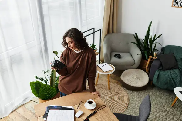 Curly-haired woman enjoys her remote work while exploring photography in her cozy space. — Stock Photo
