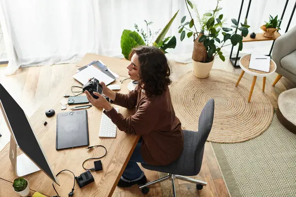 Curly-haired freelancer immersed in creative tasks, surrounded by plants and design tools. — Stock Photo
