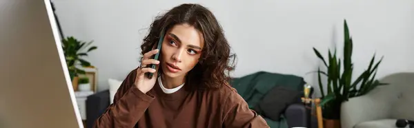 Curly-haired young woman engages in a work call at her home office, focused and creative, banner — Stock Photo