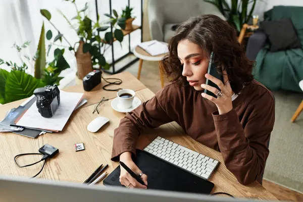 Young woman with curly hair focuses on editing and retouching while on a call at home. — Stock Photo