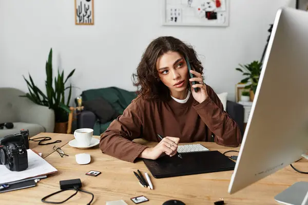 Young woman with curly hair focused on editing while using a graphic tablet at home. — Stock Photo