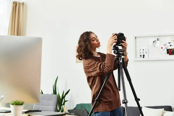 Curly-haired freelancer focused on her camera setup in a cozy home workspace. — Stock Photo