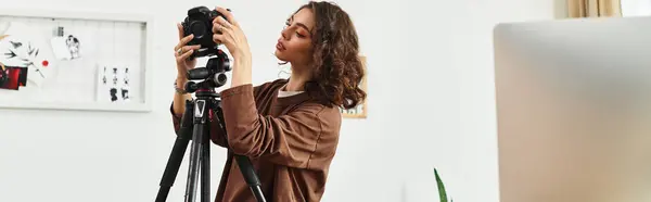 A young woman with curly hair sets up her camera to work on photography projects from home, banner — Stock Photo