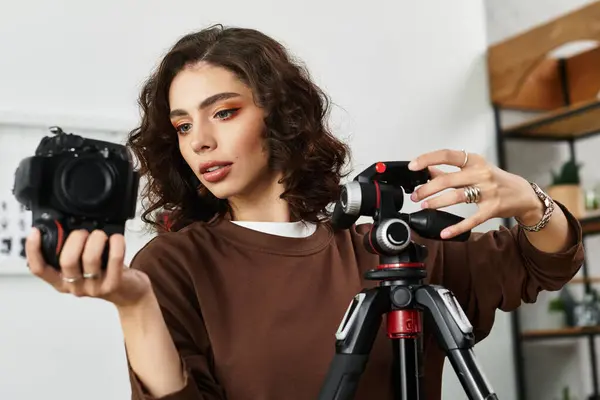 Curly-haired woman adjusts her camera setup while enjoying remote work in a cozy space. — Stock Photo