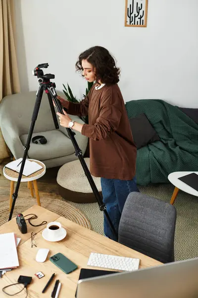 Curly-haired woman adjusting her camera in a stylish and vibrant remote work setting — Stock Photo