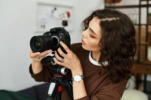Curly-haired freelancer focuses on her camera while working in a cozy home office space. — Stock Photo