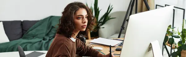 A young woman with curly hair focuses on her tasks while working from her cozy home office, banner — Stock Photo