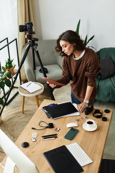 A young woman with curly hair organizes her creative space while capturing moments from home. — Stock Photo