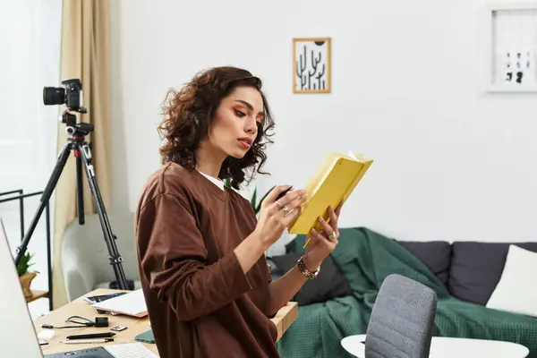 A young woman with curly hair writes notes in a cozy home workspace filled with inspiration. — Stock Photo