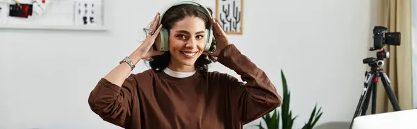 A young woman with curly hair happily wearing headphones, banner — Stock Photo