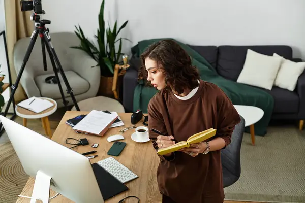 Young woman with curly hair edits photos at home using a graphic tablet and stylus pen. — Stock Photo