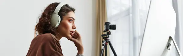 Curly-haired freelancer focuses intently on her creative work in a modern home setting, banner — Stock Photo