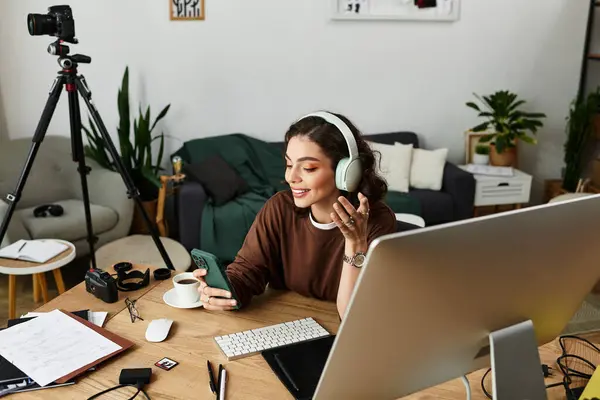 Young woman with curly hair focuses on retouching images using a graphic tablet while smiling. — Stock Photo