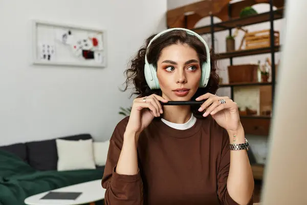 A young woman with curly hair is focused on her tasks in her cozy home office. — Stock Photo