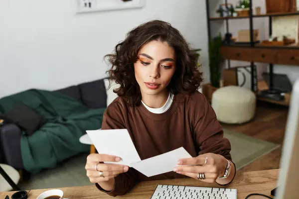 Young woman reviews her creative work in a cozy home office environment. — Stock Photo