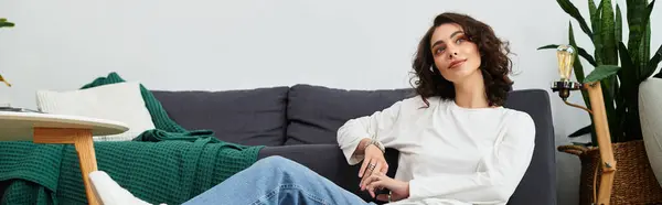 Curly-haired woman takes a peaceful moment in her modern apartment, enjoying her cozy surroundings, banner — Stock Photo