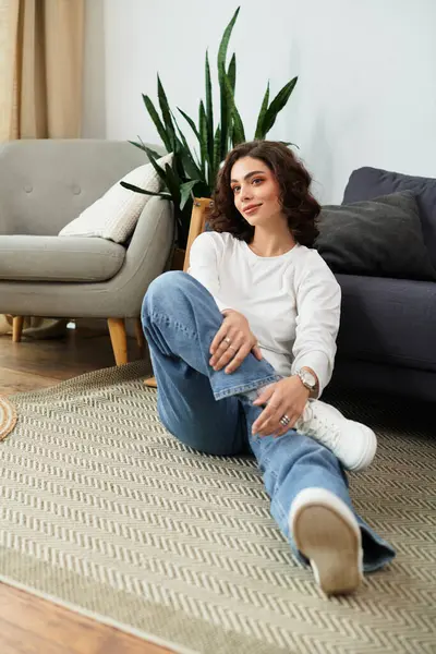 Curly-haired woman enjoys a peaceful moment on the floor of her cozy living space. — Stock Photo