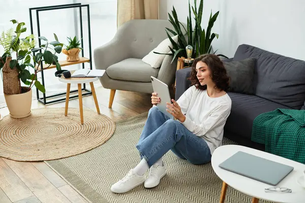 A young woman with curly brown hair enjoys a peaceful moment in her modern apartment. — Stock Photo