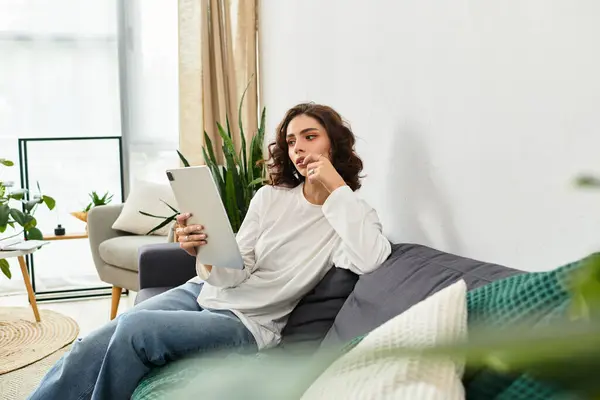 Young woman with curly brown hair enjoys a peaceful moment in her stylish apartment. — Stock Photo