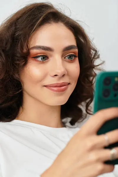A young woman with curly brown hair enjoys a quiet moment in her modern apartment. — Stock Photo
