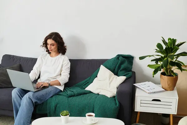 Young woman with curly hair engages in remote work at her comfortable home space. — Stock Photo