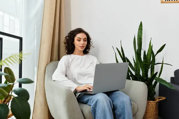 Young woman with curly hair works comfortably from home in creative surroundings. — Stock Photo