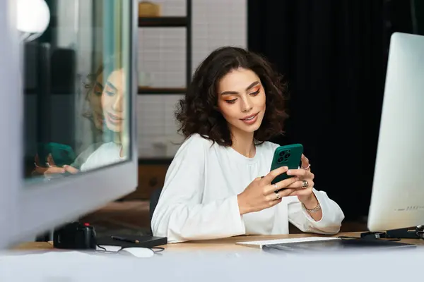 A beautiful young woman with curly hair engages in freelance work at her cozy home office, smiling. — Stock Photo