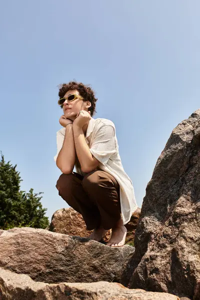 A young man dressed fashionably explores the outdoors while resting in nature's embrace. — Stock Photo