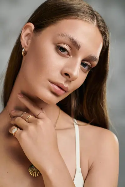 A young woman with tan skin and natural makeup showcases her beauty in a studio during summer. — Stock Photo