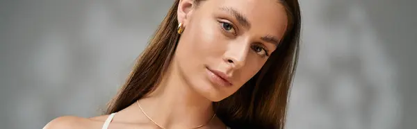 A young woman showcases her flawless tan skin and natural makeup in a summer studio, banner — Stock Photo