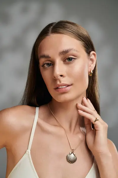 A beautiful young woman shows off her natural makeup and tan skin in a summer-themed studio. — Stock Photo