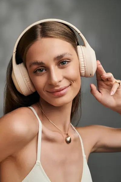 A radiant woman with tan skin and headphones showcases her natural makeup in a summer studio setting. — Stock Photo