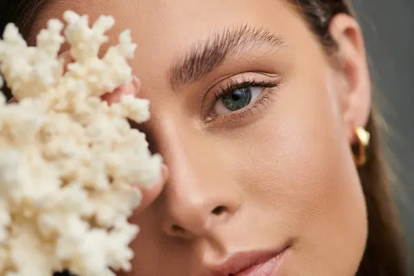 A young woman showcases her natural beauty with perfect skin in a summer studio setting. — Stock Photo