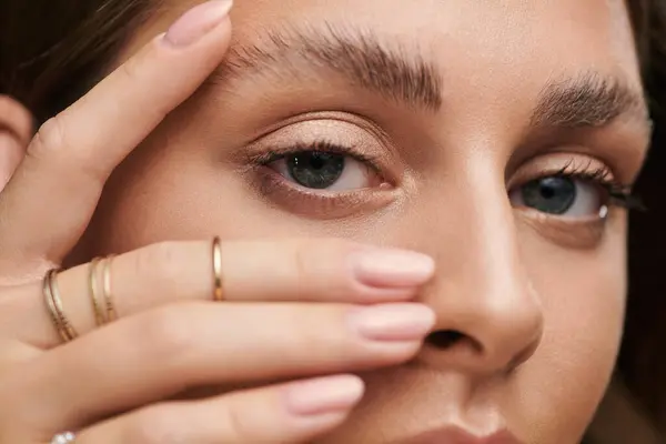 A young woman showcases her radiant tan skin and natural makeup in a studio setting. — Stock Photo