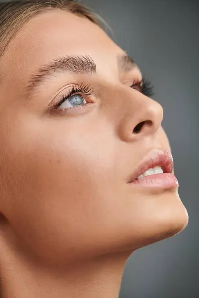 A pretty young woman with tan skin enjoys a moment in the studio, highlighting her natural makeup. — Stock Photo