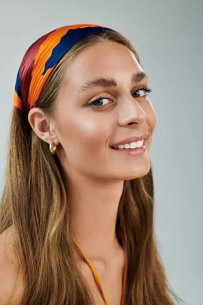 A young woman with tan skin and a colorful headscarf smiles in her summer outfit. — Stock Photo