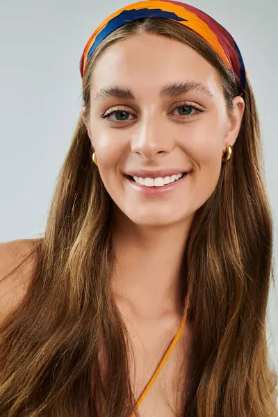 Young woman with tan skin and a colorful headscarf poses with a radiant smile in a studio setting. — Stock Photo
