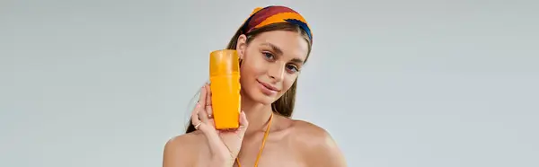 A young woman confidently poses in a vibrant summer headscarf with spf, banner — Stock Photo