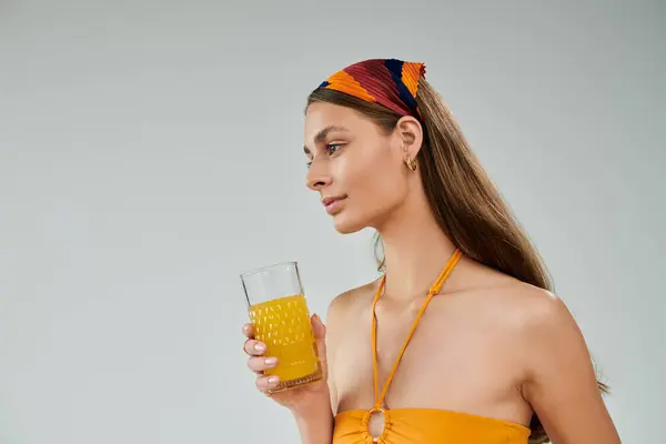 A young woman with tan skin confidently poses in a vibrant summer outfit, drink in hand. — Stock Photo