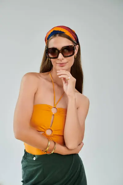 Pretty young woman with a headscarf poses in a bright summer outfit, radiating charm and style. — Stock Photo