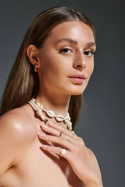 A young woman with tan skin shines in a seashell necklace and trendy outfit. — Stock Photo