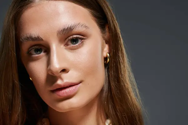 A confident young woman with tan skin models against a plain backdrop. — Stock Photo