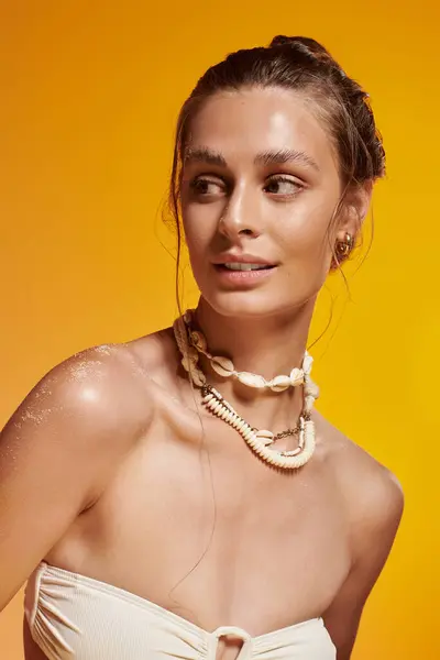 A young woman with tan skin models a trendy summer outfit and seashell necklace. — Stock Photo