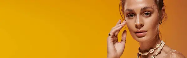 A young woman with tan skin showcases her summer style while posing gracefully in a studio, banner — Stock Photo