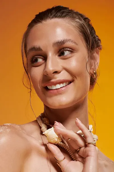 A stunning young woman with tan skin poses confidently in a seashell necklace and summer outfit. — Stock Photo